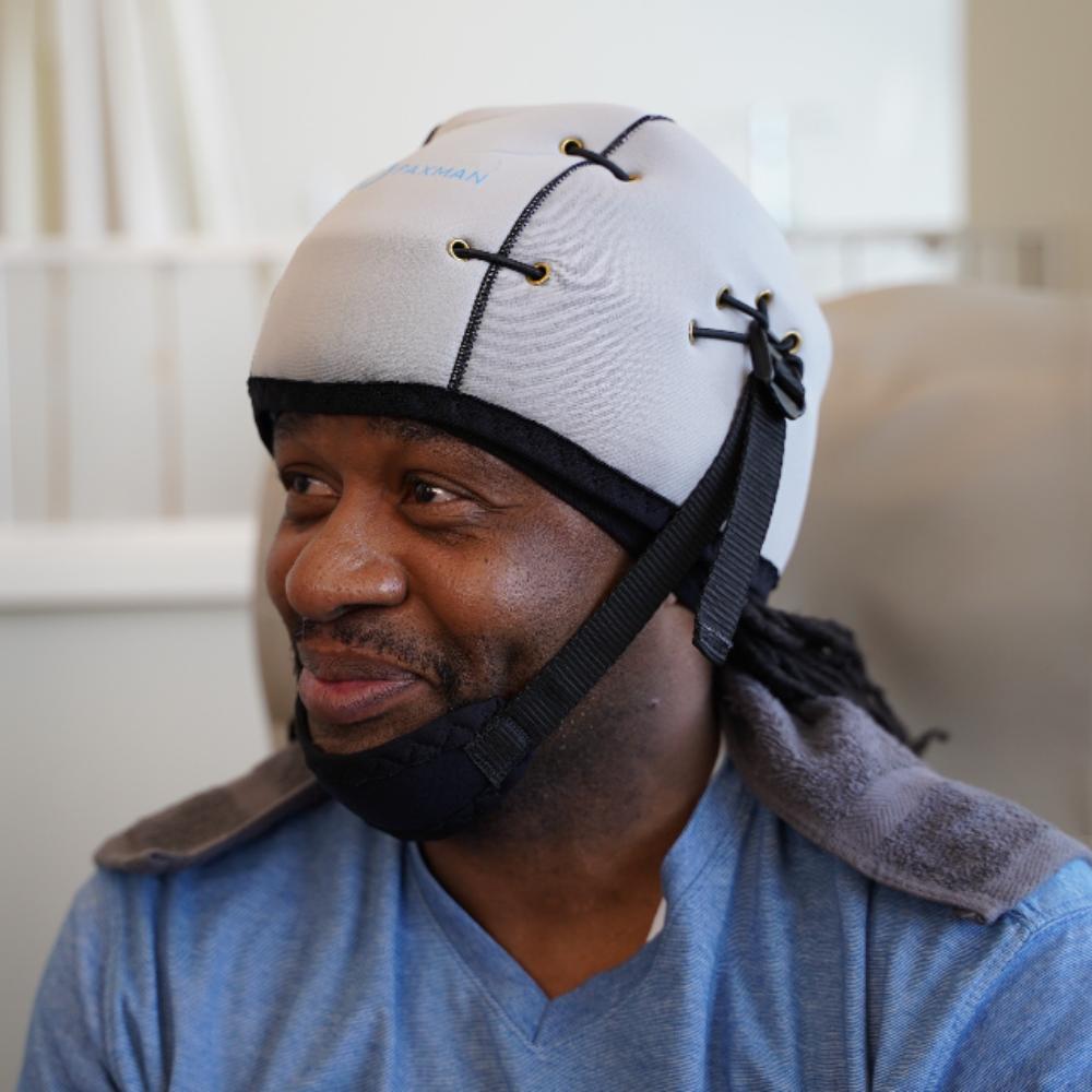 Male patient up close wearing paxman scalp cooling cold cap